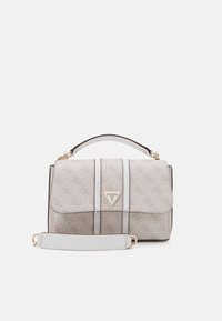 Beige Guess käsilaukku, jossa on monogrammikuosi, kultainen kolmion logo edessä, ylhäällä oleva kahva, ja irrotettava olkahihna valkoisella taustalla.