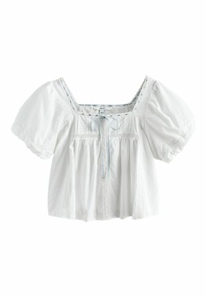 Weiße Bluse mit kurzen Ärmeln, quadratischem Ausschnitt, Spitzenbesatz, vorderen Biesen und einer kleinen Schleife in der Mitte.