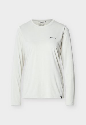 Λευκό γυναικείο μπλουζάκι Patagonia με μακριά μανίκια, στρογγυλή λαιμόκοψη και μικρό μαύρο λογότυπο στο αριστερό μέρος του στήθους, σε απλό φόντο.