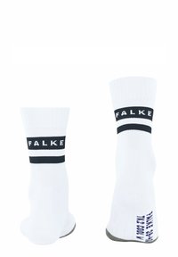 Calcetines blancos con textura acanalada, con una banda azul marino que lleva el logo de "FALKE". Amortiguación en el tobillo y detalle en la suela en gris.