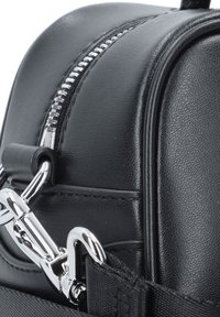 Borsa in pelle nera con hardware argentato, caratterizzata da una texture liscia, forma curva e un dettagliato zip prominente lungo la parte superiore.