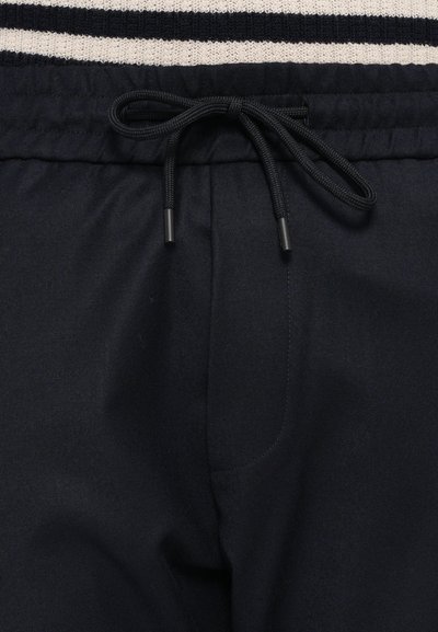 Pantalones de chándal azul marino con cinturilla elástica, cierre ajustable con cordón y tejido suave con un ligero brillo.