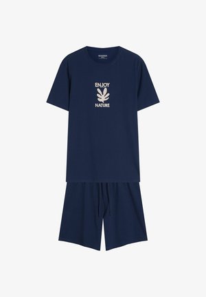 Granatowy zestaw odzieży domowej z bawełny, w skład którego wchodzi koszulka z krótkim rękawem z napisem "CIESZ SIĘ NATURĄ" oraz dopasowane szorty z elastyczną talią na sznurek.