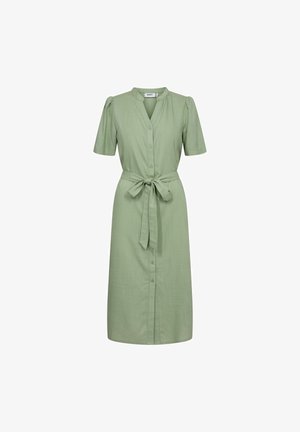 Zelena haljina do koljena s kratkim rukavima, gumbima sprijeda, ovratnikom i vezanjem u struku. Napravljena od glatkog materijala s blagom teksturom.