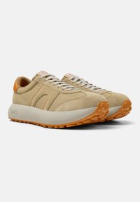 Zapatillas de ante y malla beige con acentos naranjas, forma redondeada, diseño ligero y suela de goma texturizada. Cierre con cordones.