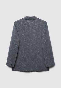 Blazer grigio scuro con maniche lunghe e pois bianchi, mostrato di spalle su uno sfondo chiaro e neutro.