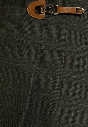 Tessuto a quadri verde scuro con sottili linee rosse, dotato di una tracolla in pelle marrone e dettagli con fibbia dorata.
