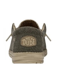 Scarpa slip-on in tessuto grigio intrecciato con retro arrotondato, suola in gomma beige e un evidente'etichetta "HEY DUDE" sul retro.