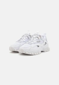 Baskets blanches de sport avec une tige en maille et synthétique, semelle texturée et accents argentés. Présente une semelle intermédiaire épaisse et un système de laçage proéminent.