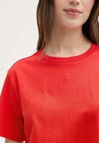 Rode katoenen T-shirt met een ronde hals, korte mouwen en een subtiele geborduurde logo op de borst. Glad textuur, casual fit.