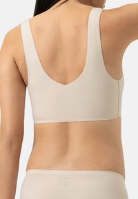 Beige cropped bh met brede banden en een diepe scooprug. Gladde textuur met een naadloos ontwerp, dat een minimalistische esthetiek biedt.