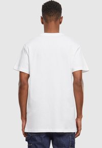 White cotton t-shirt with a relaxed fit, short sleeves, and a crew neckline. The back is smooth with no printed designs or accents.