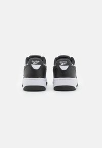 Ténis Reebok em preto e branco com parte superior em couro, colarinho acolchoado e sola em borracha. Apresenta o logo no calcanhar e costura em contraste.