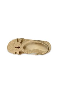 Sandalia de cuerda trenzada en beige claro, con un diseño anudado, suela texturizada y plantillas suaves sin herrajes o acentos visibles.