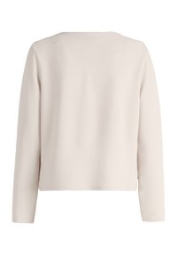 Light beige long-sleeve top, slightly cropped, textured fabric, round neckline, no visible seams, smooth finish, simple design.