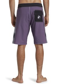 Fioletowe szorty plażowe z czarną kieszonką na patch. Posiadają elastyczny pasek w talii, kontrastowe szwy oraz boczny panel z delikatnym gradientowym wzorem.
