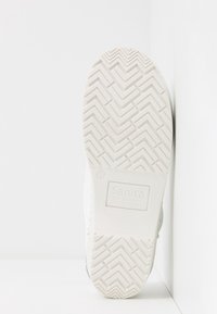 Semelle de sabot blanche avec motif en chevrons et nom de marque embossé "Sanita The Original Danish Clogs" en taille 37.