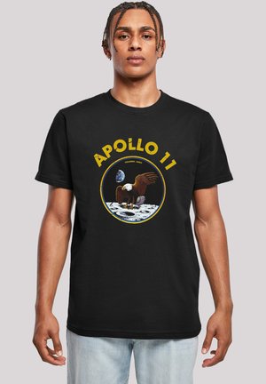 Black cotton t-shirt featuring a circular graphic depicting an eagle on the moon with the text "APOLLO 11" in yellow above and Earth in the background.