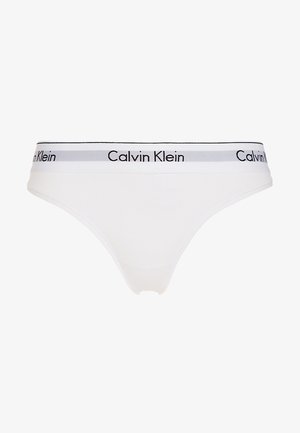 Witte katoenen string met een zwart en grijs elastische tailleband waarin 'Calvin Klein' in herhaalde tekst staat. Glad oppervlak, minimalistisch ontwerp.