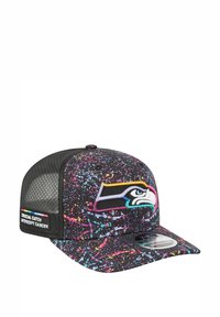 Schwarze Kappe mit einem bunten Spritzmuster, mit einem gestickten Teamlogo auf der Vorderseite und einem Mesh-Rücken. Das Seitenetikett lautet "Crucial Catch".