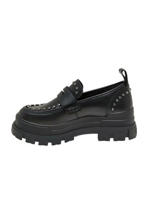 Mocasines negros con suela de goma gruesa, con un upper de cuero liso adornado con tachuelas metálicas a lo largo de los lados y la puntera.