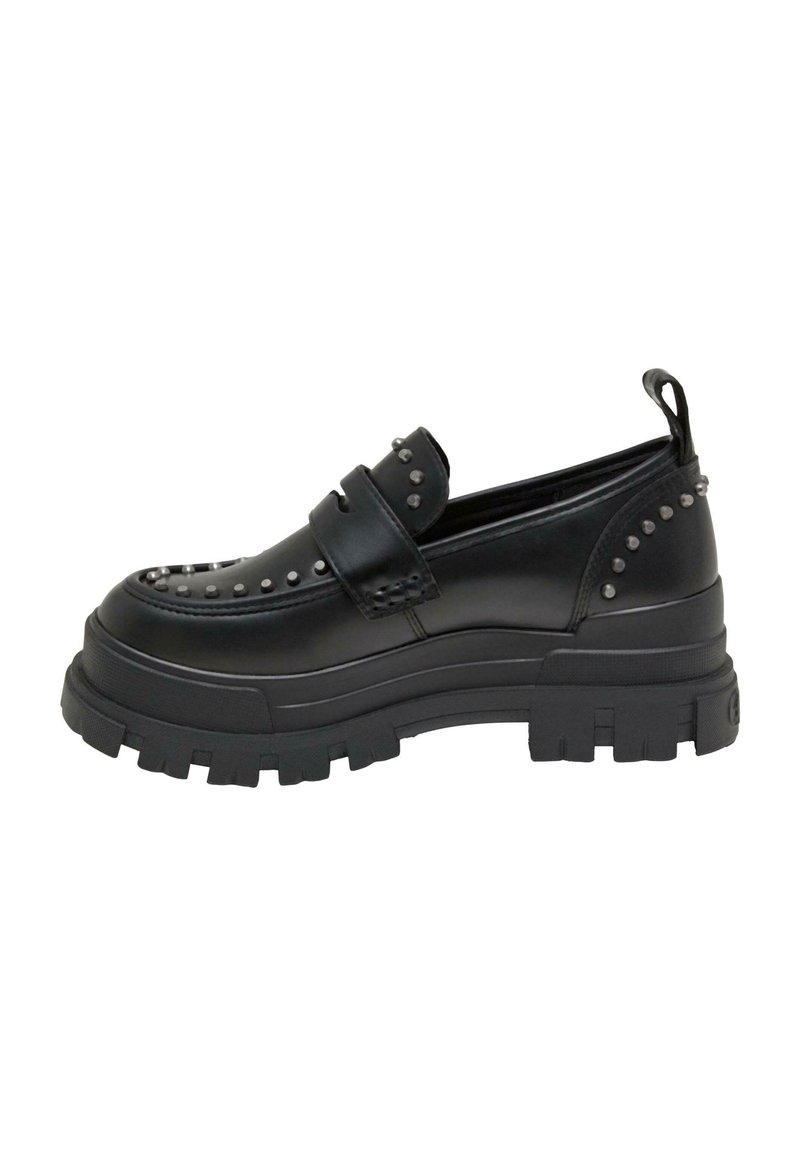 Svarta loafers med en kraftig gummisula, som har ett slätt skinnövre prytt med metalliska nitar längs sidorna och tån.