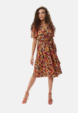 Floral wrap dress in orange and brown with short sleeves, a belted waist, and a knee-length hem, featuring large, colorful flower patterns.