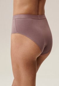 Fioletowe, bawełniane majtki z wysokim stanem o miękkiej teksturze, elastycznym pasku i bezszwowym designie, wyeksponowane z boku.