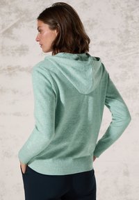 Mintgrön hoodie med en strukturerad yta, långa ärmar och ribbade mudd och fåll. Har en dragsko i huvan och har en avslappnad passform.