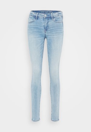 Lys blå skinny jeans laget av denim. Har en klassisk fem-lomme design, lett falming, og en glidelåsflue med knappelukking.