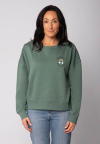 Grüner Baumwollpullover mit rundem Ausschnitt, überschnittenen Schultern und gerippten Bündchen, verziert mit mehrfarbiger bestickter Schrift und Design.