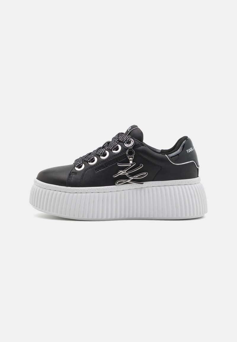 Schwarze Leder-Sneaker mit dicker weißer Plateausohle, silbernen Details und gemusterten Schnürsenkeln. Mit Logodetails an der Ferse.