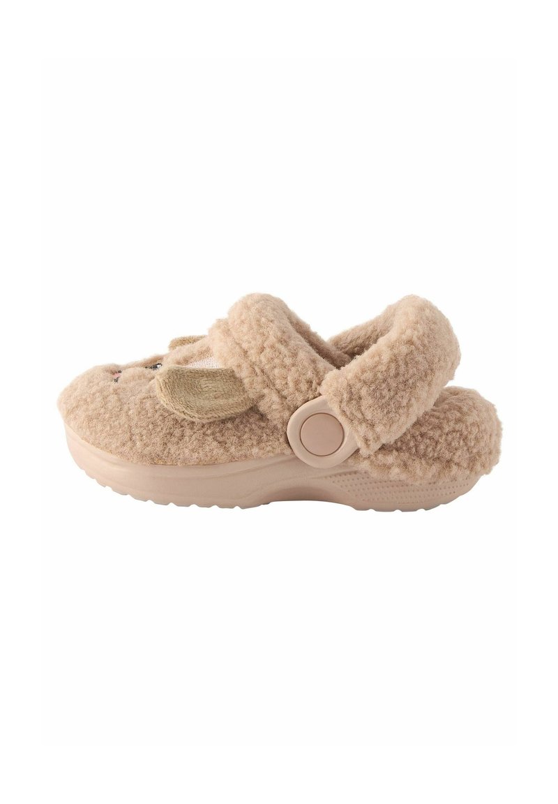 Beige fluffig innesko med en texturerad ovansida, justerbar rem och gummisula. Har ett sött djuransikte framtill. Mjukt och mysigt design.