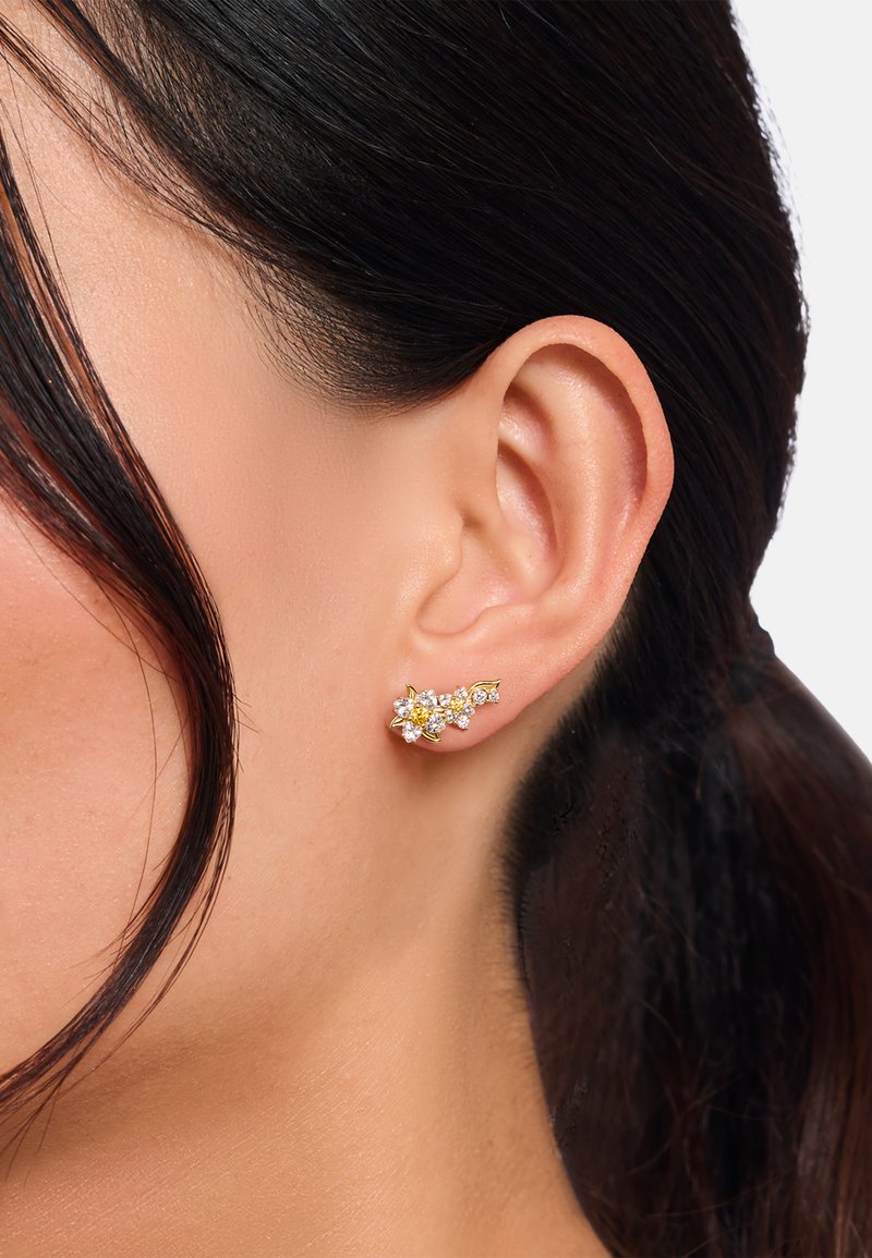 Gold-colored floral stud earrings, featuring clear and yellow crystals. Elegant design with petal accents and a textured finish.