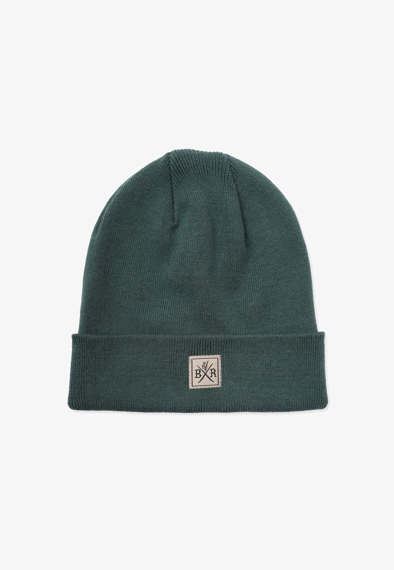 Neulepipo syvässä vihreässä, jossa on käännettävä reuna. Siinä on suorakulmainen beigepatch, jossa on ristikkäisten työkalujen emblem. Pehmeä rakenne.