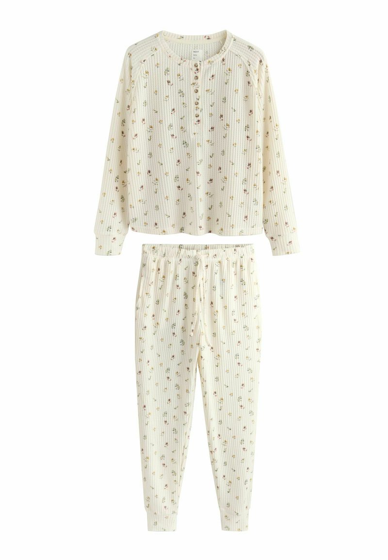 Pyjama-Set mit Blumenmuster aus geripptem Stoff; langärmeliges Oberteil mit Knopfleiste und Hose mit elastischem Bund. Die Farben sind Creme und Pastelltöne.