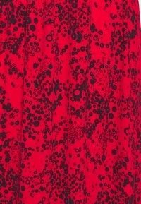 Tessuto rosso con un denso motivo floreale nero, con varie forme e dimensioni di fiori. Texture morbida, design plissettato per una fluidità elegante.