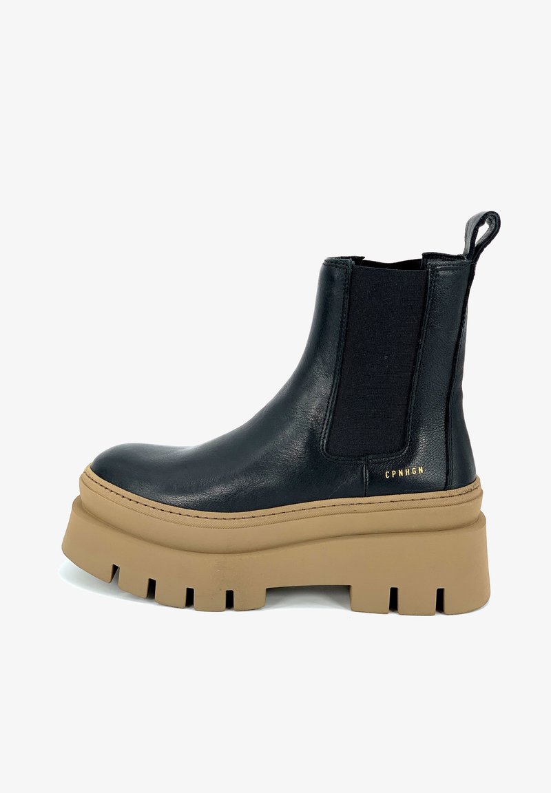 Bottine en cuir noir avec panneaux latéraux élastiques, semelle plateforme beige épaisse, coutures apparentes et logo de la marque sur le côté.