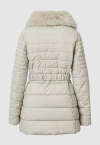 Cappotto imbottito beige chiaro con colletto in pelliccia sintetica, vita elastica e motivo trapuntato verticale. Texture liscia e maniche lunghe.