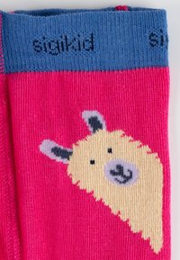 Kniestrümpfe in leuchtendem Pink mit einem blauen Bund, versehen mit einem gestickten cremefarbenen Lama-Motiv und schwarzen Akzenten.