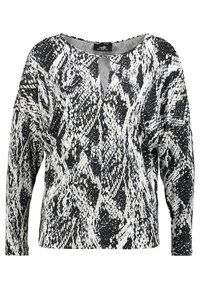 Czarna i biała bluzka z długim rękawem w wzór węża, z dekoltem w serek i luźnym krojem. Wykonana z gładkiego, miękkiego materiału.