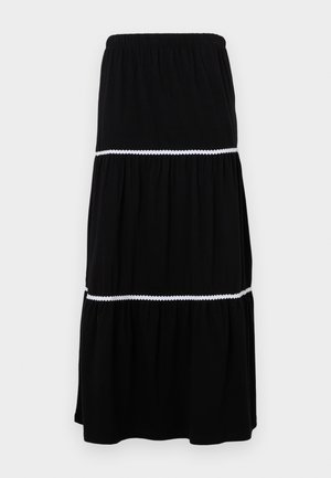 Crna višeslojna maksi suknja napravljena od mekog materijala; s elastičnom gumom u struku i bijelim valovitim detaljima između slojeva za dodatni efekt.