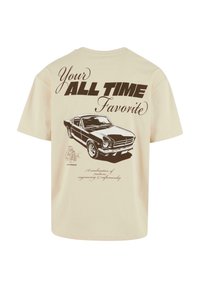 T-shirt en coton beige avec une illustration de voiture vintage et le texte : "Votre Favori de Tous les Temps" avec un slogan en dessous.