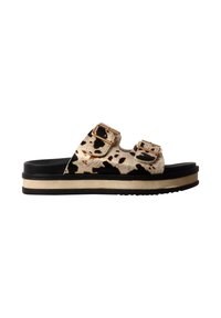 Sandale slide avec brides imprimé vache noir et beige, deux boucles dorées, semelle noire et bande beige sur la semelle intermédiaire.