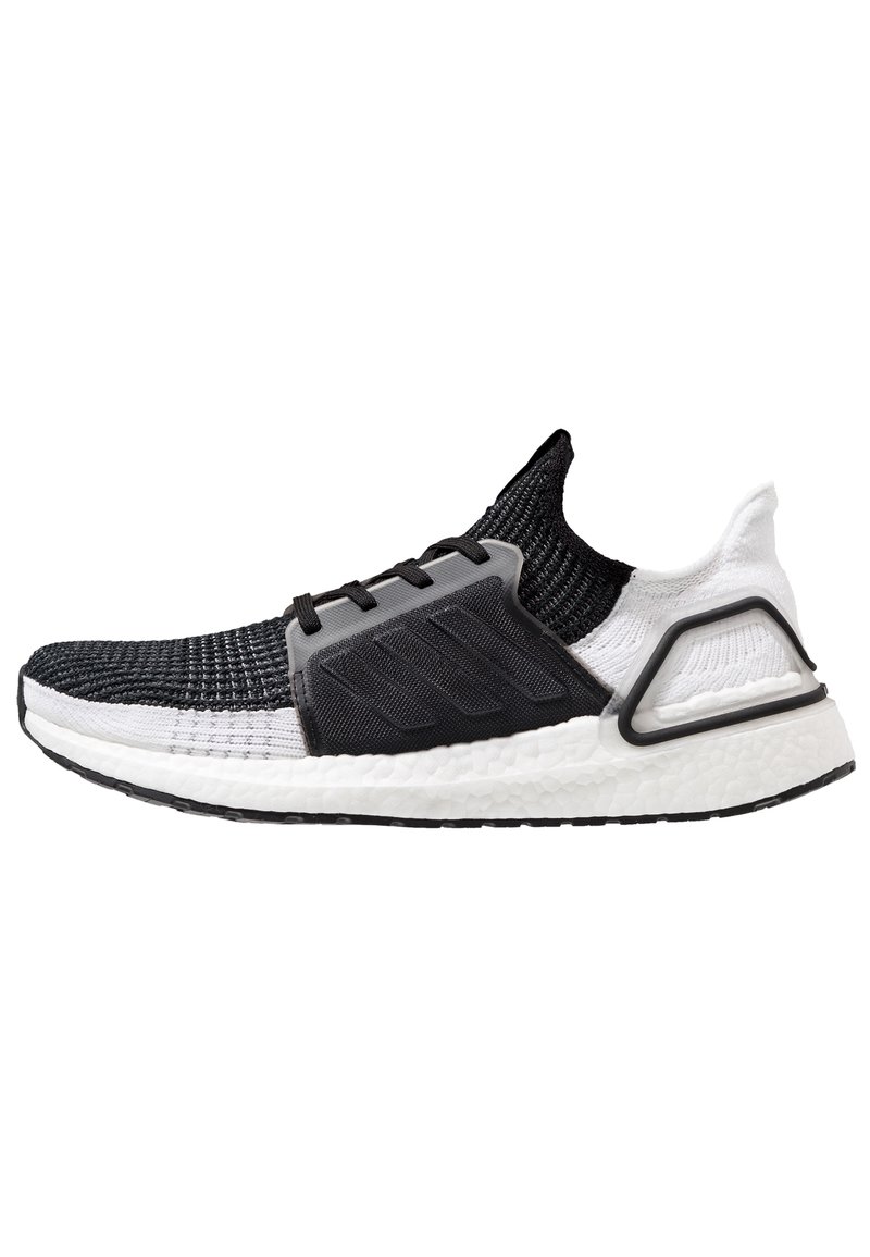 Czarnobiałe buty sportowe zdzianą cholewką, teksturowaną szaro-skalową częścią środkową i białą wyściełaną podeszwą; posiadają zakrzywiony czarny akcent na pięcie.