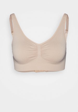 Beige sports bra with a fitted design, smooth texture, wide straps, and a gathered center detail. Adjustable back closure for comfort.
