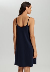 Abito senza maniche blu navy con una vestibilità comoda, realizzato in tessuto morbido. Presenta un orlo arrotondato e spalline regolabili.