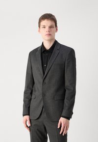 Grijze kostuum met een gestructureerde stof, enkel-breasted ontwerp, notch revers en twee knopen. Draag boven een zwart shirt, slim fit stijl.