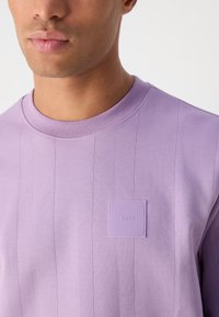 Λαχανί φούτερ με λαιμόκοψη από απαλό βαμβάκι, με κάθετη ραφή και υφασμένο τετράγωνο λογότυπο στο αριστερό στήθος.