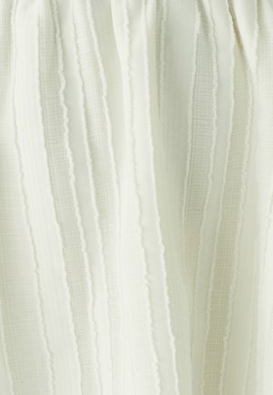 Balts plīsēts audums ar vertikālām svītrām, kam ir teksturēta virsma. Mīksts, viegls materiāls ar smalkām raksta variācijām.